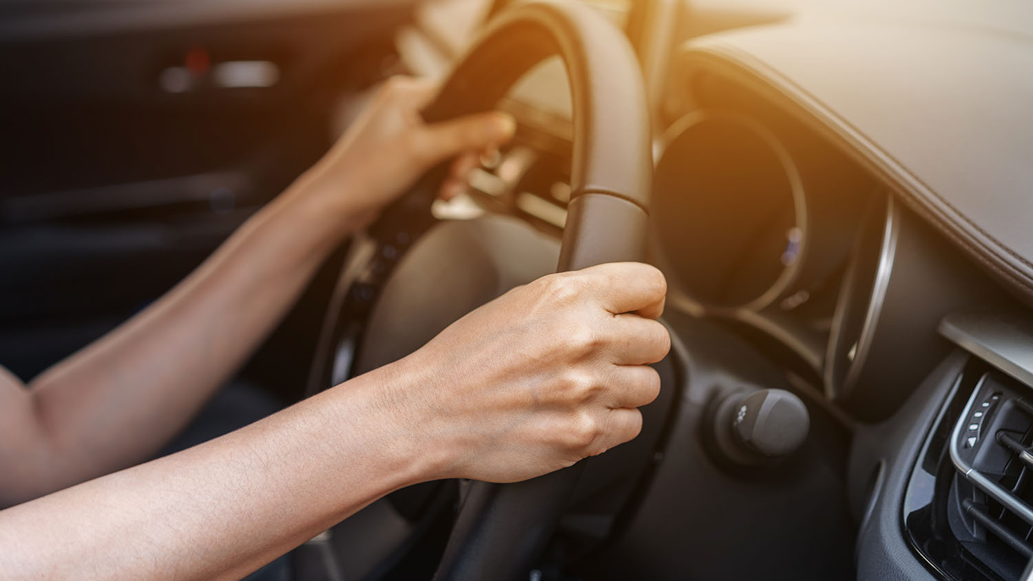 woman driving with both hands on the steering wheel 