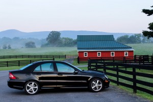 black car parked outside red house