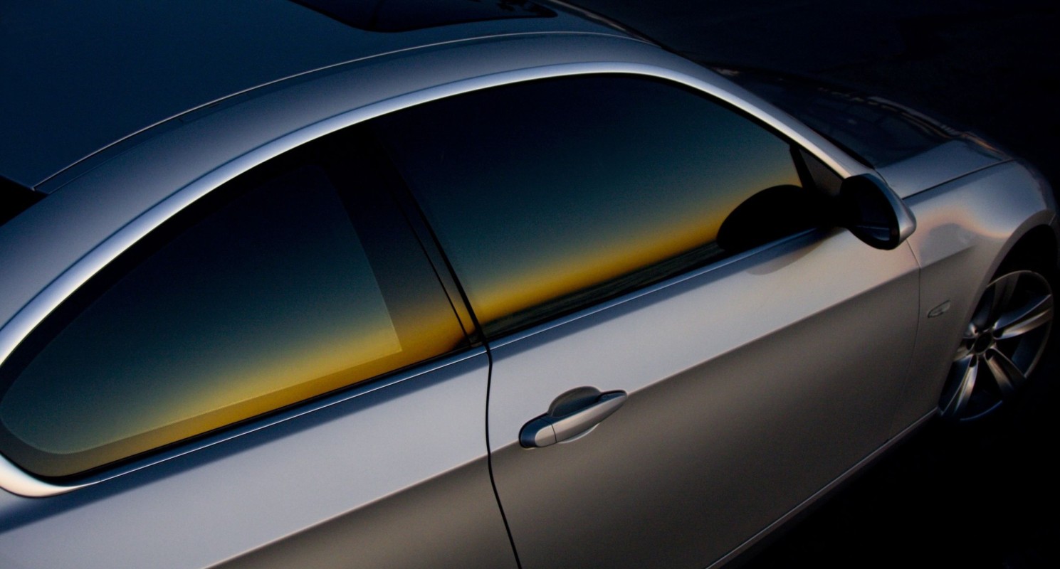 black dodge charger with tinted indows is parked on the road in the countryside in the sunshine