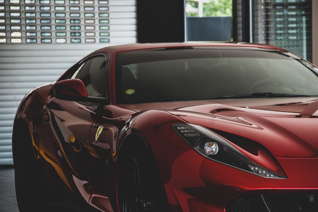 A red car with tinted windshield and passenger windows.