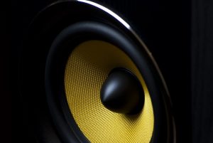 Car stereo speaker with a yellow cone.