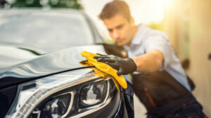 Man washing and detailing his black car