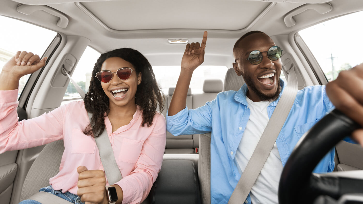 Couple listening to the car radio and enjoying the music on the road trip